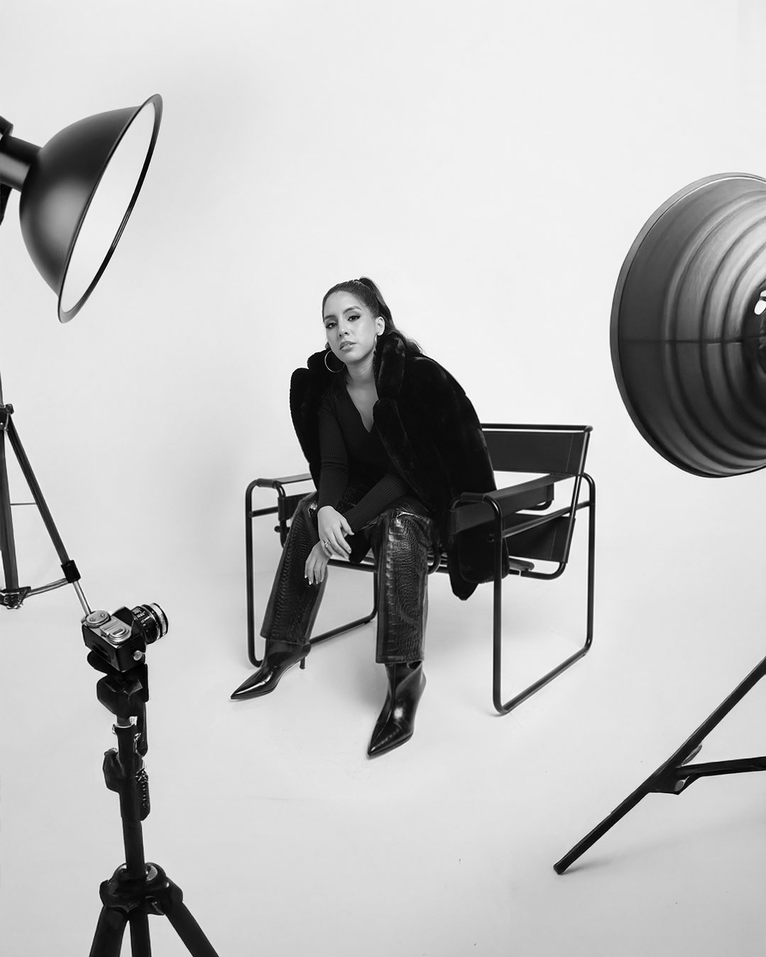 Marcela seated in a photo studio between studio lights